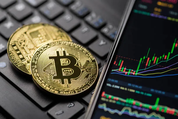 Біткоїн монети та графік криптовалюти на екрані