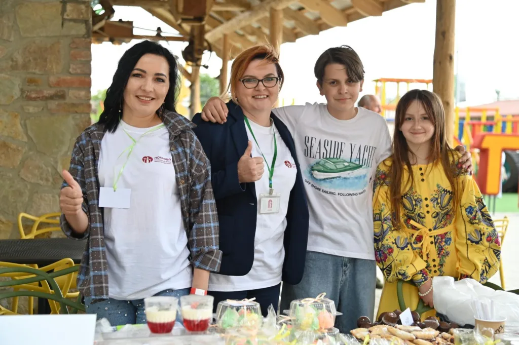 Люди на благодійному ярмарку з солодощами