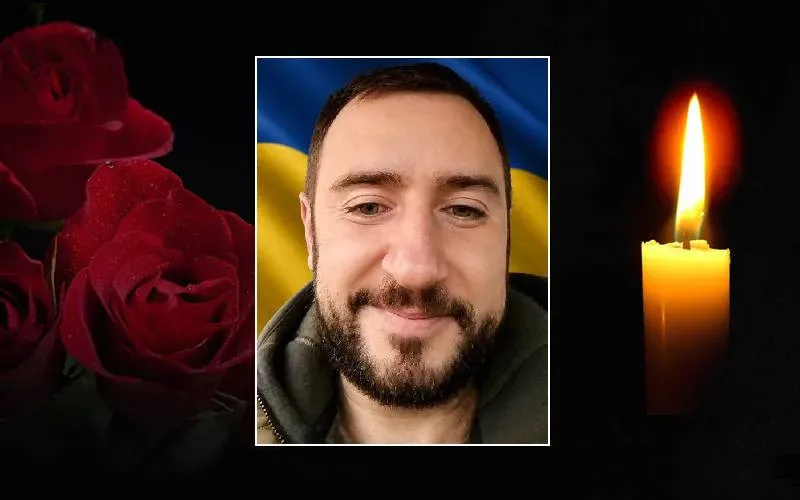 Портрет чоловіка, свічка пам’яті та червоні троянди