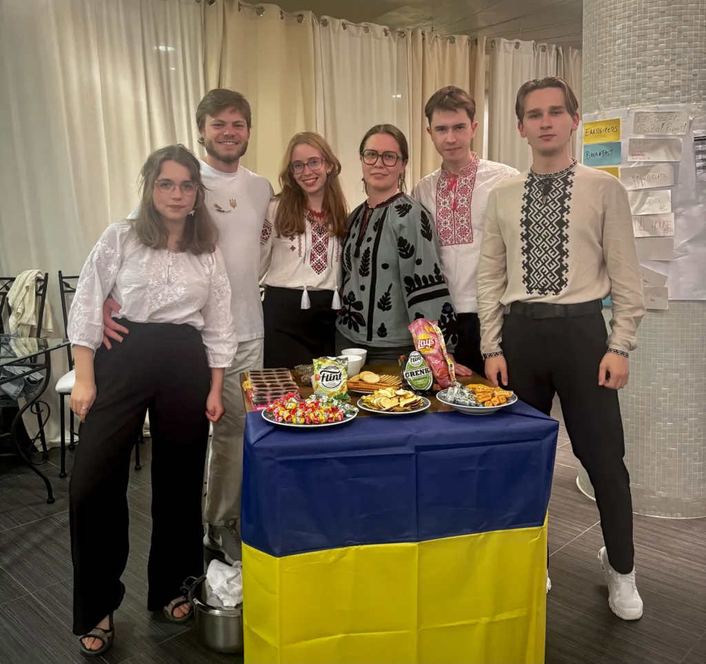 Люди у вишиванках біля столу з українськими стравами