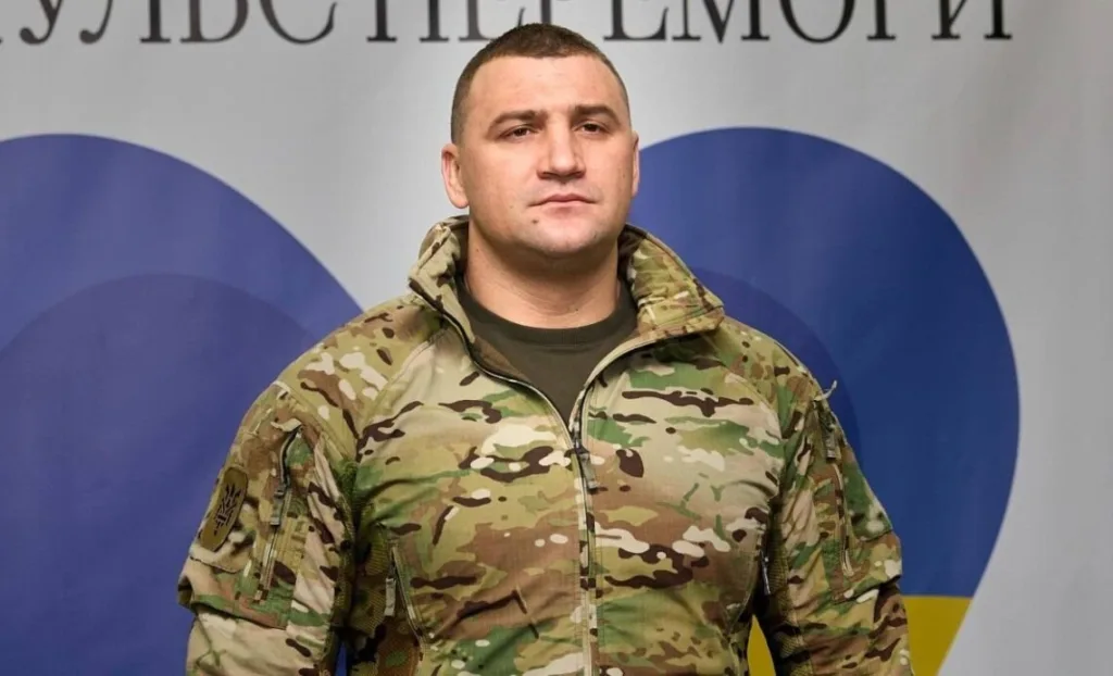 Військовий у камуфляжі на тлі прапора України