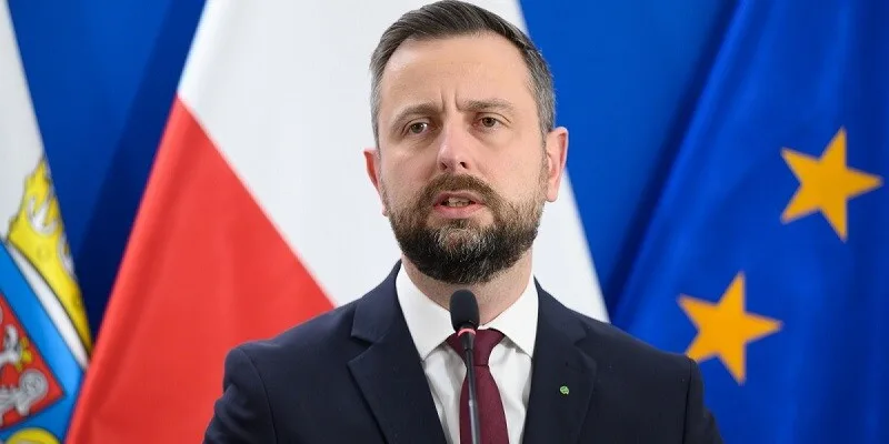 Чоловік виступає на пресконференції із прапорами позаду