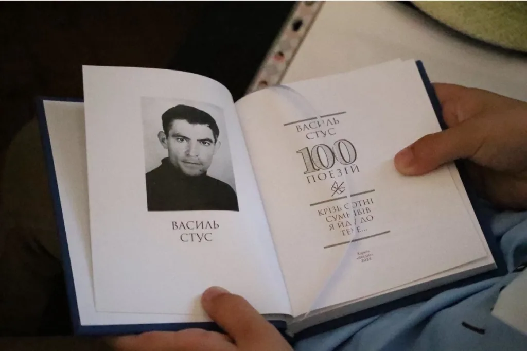 Людина читає книжку Василя Стуса сто поезій