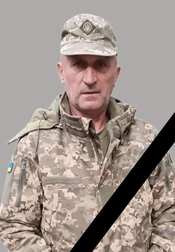 Український військовий у камуфляжі з чорною стрічкою