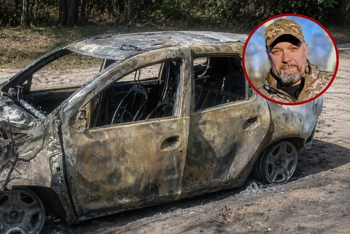 Згорілий автомобіль та військовий у камуфляжі