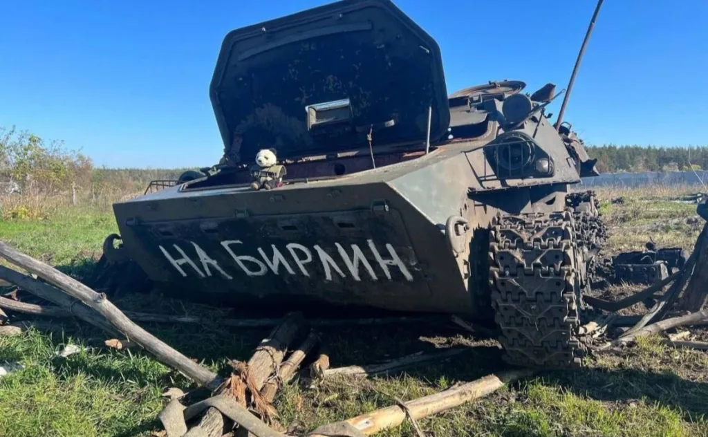Підбитий бронетранспортер у полі з написом