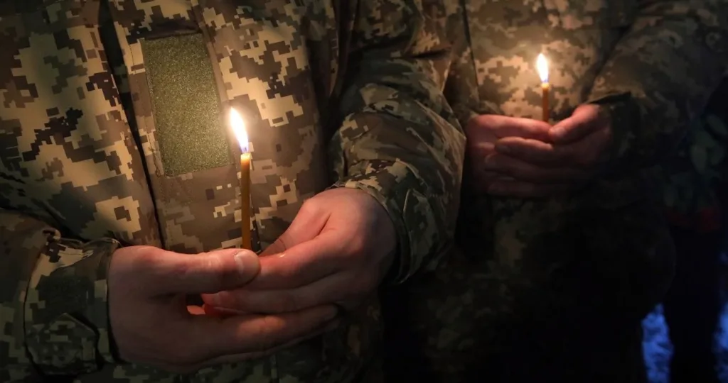 Військові тримають свічки під час поминальної церемонії