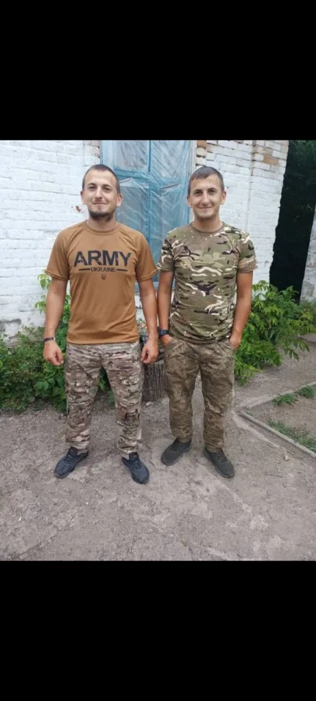 Двоє чоловіків у військовій формі біля будинку