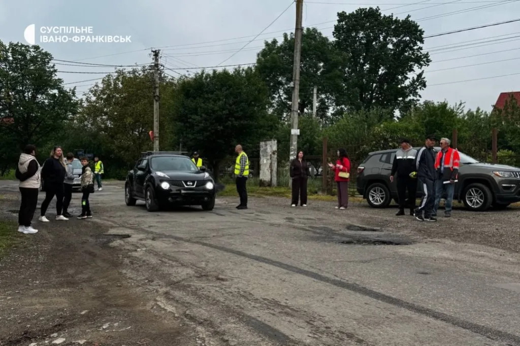 Люди та автомобілі на сільській дорозі