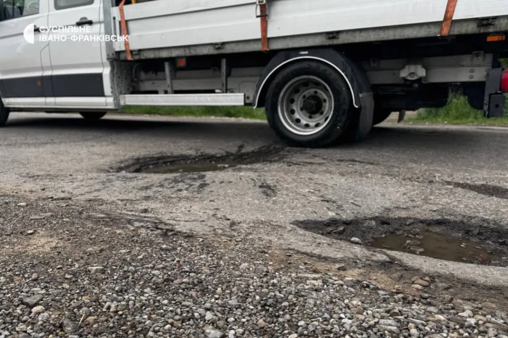 Вантажівка біля вибоїн на асфальтованій дорозі