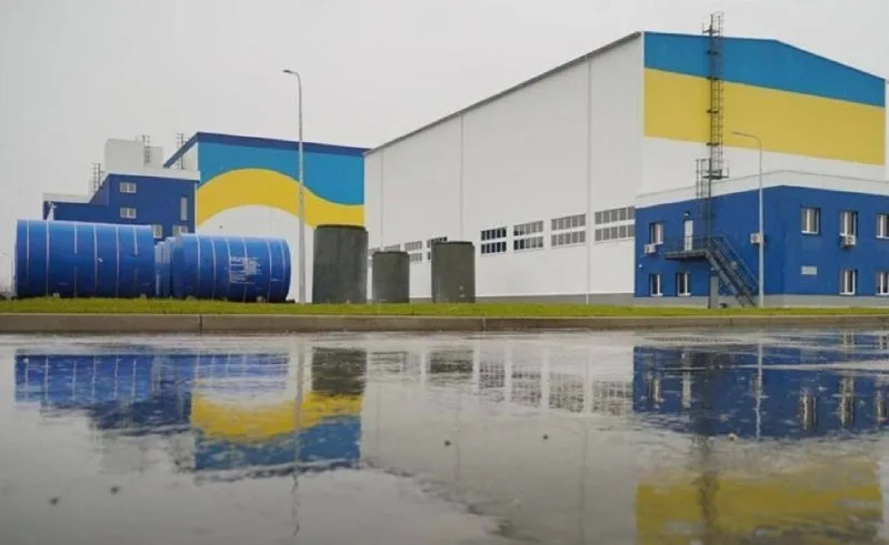 Сучасний завод з українським прапором на фасаді