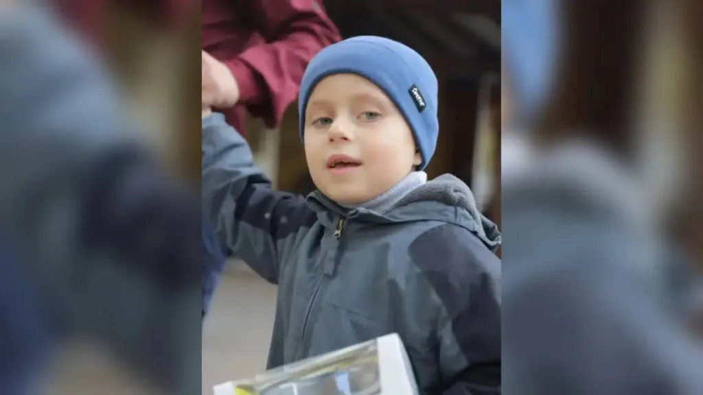 Хлопчик у синій шапці тримає подарунок