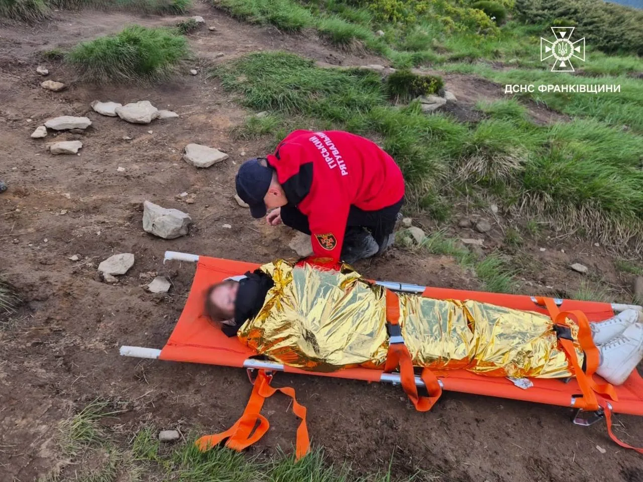 Рятувальник допомагає постраждалому в горах