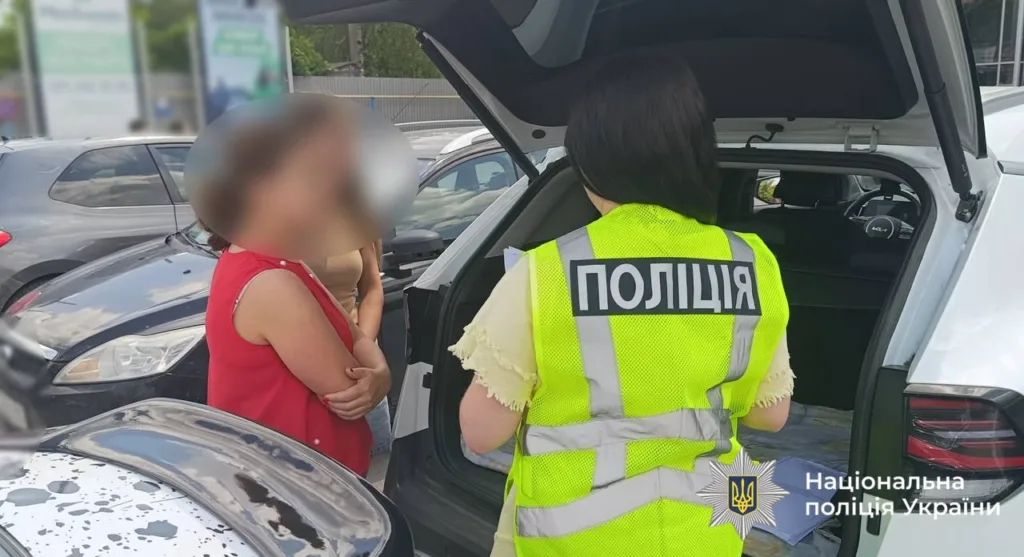 Поліція спілкується з жінкою біля автомобіля