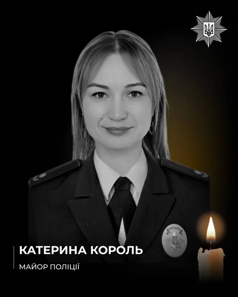 Жінка у поліцейській формі з запаленою свічкою