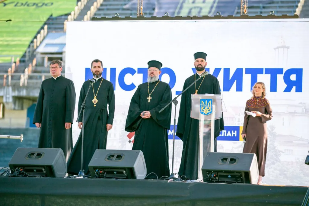 Священники та ведуча на сцені міського заходу
