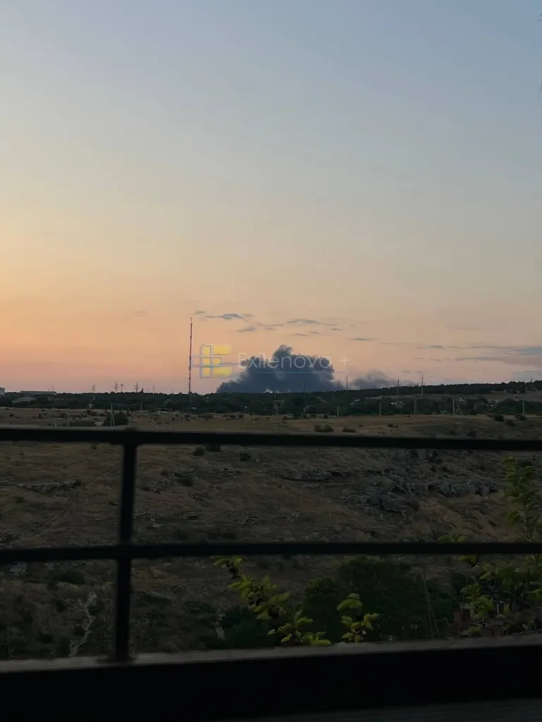 Захід сонця над полем і димом на горизонті
