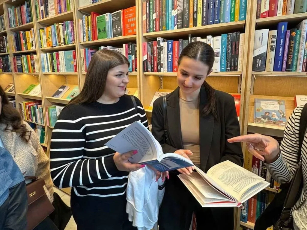 Дві жінки читають книги в книгарні