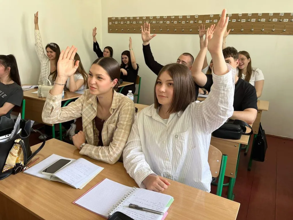 Студенти піднімають руки на уроці в аудиторії