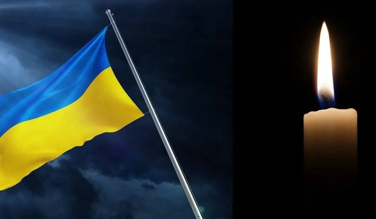 Прапор України та запалена свічка пам’яті