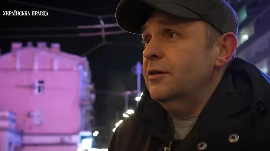 Чоловік у кепці на вулиці вночі