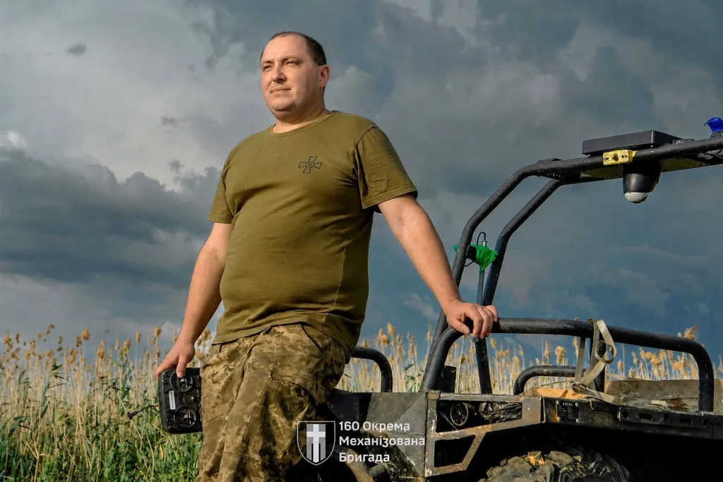 Український військовий біля техніки на полі