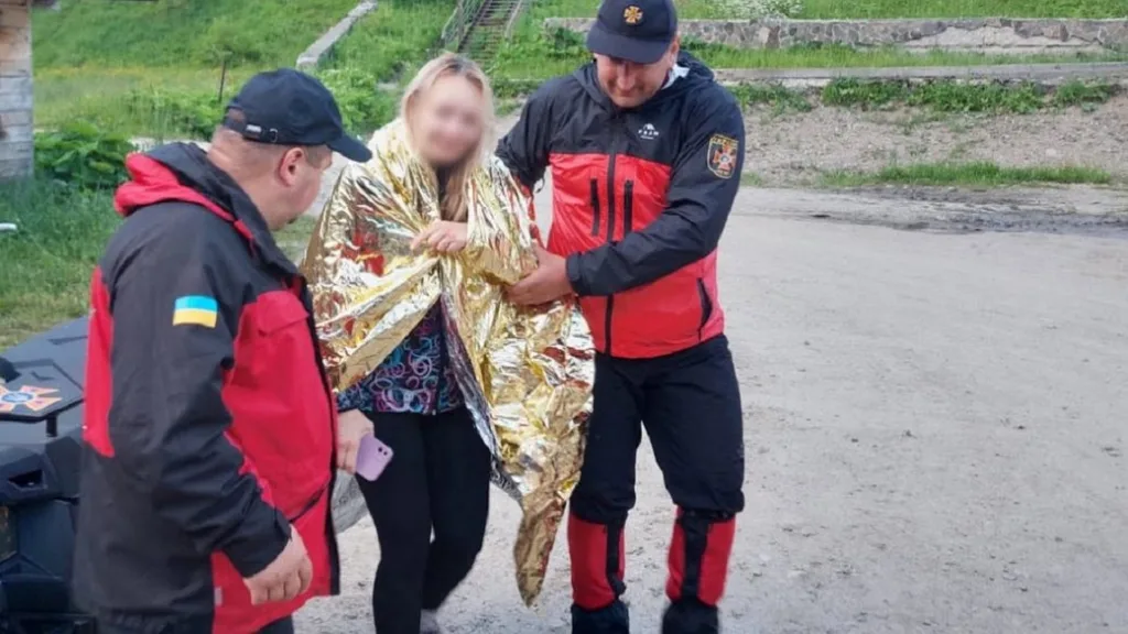 Рятувальники допомагають жінці в термоковдрі