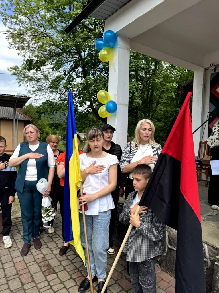 Люди з українським і червоно-чорним прапорами на заході