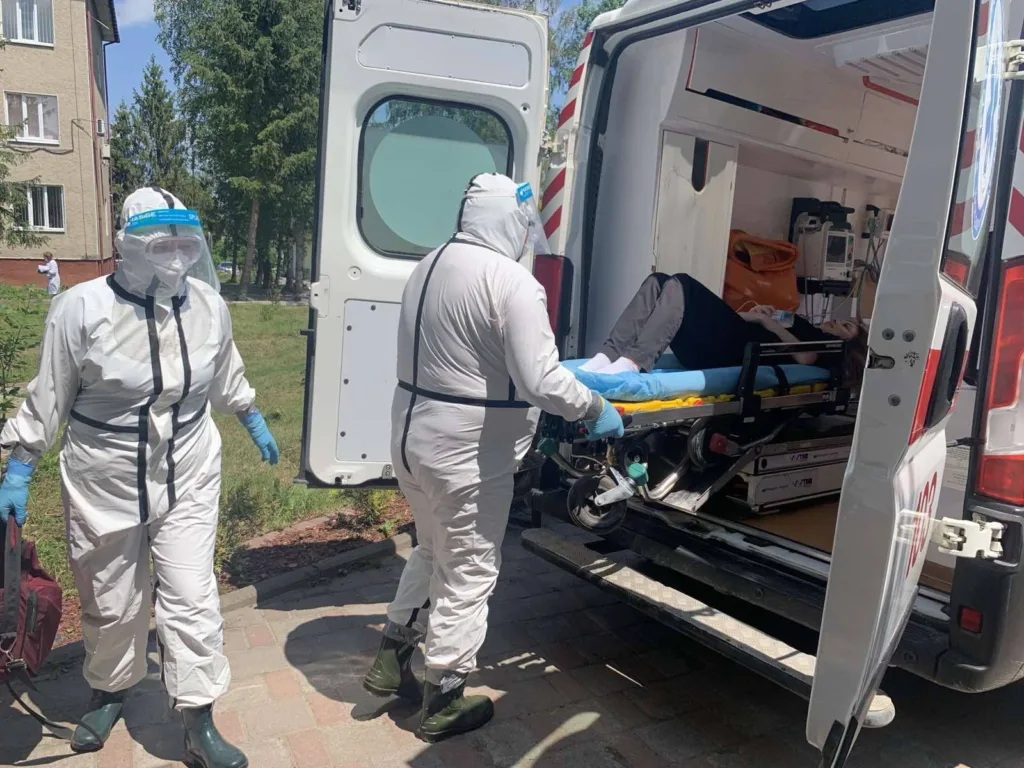 Медики у захисних костюмах вантажать пацієнта в швидку