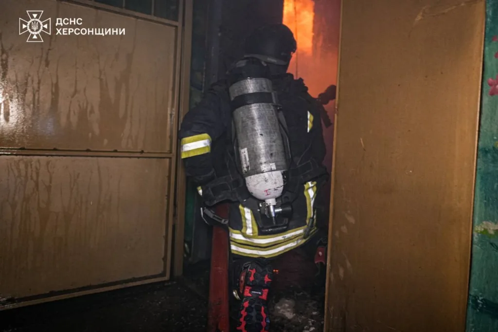 Пожежник гасить полум’я всередині будівлі