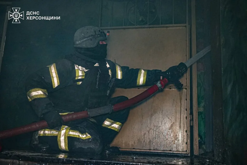 Пожежник гасить пожежу всередині будівлі