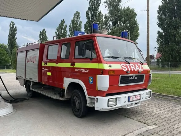 Червона пожежна машина на заправці
