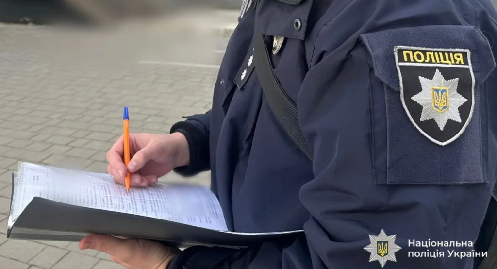 Поліцейський заповнює документ на вулиці