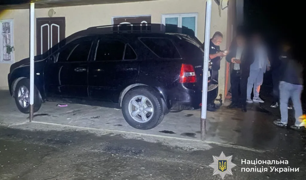 Поліція оглядає чорний автомобіль біля будинку