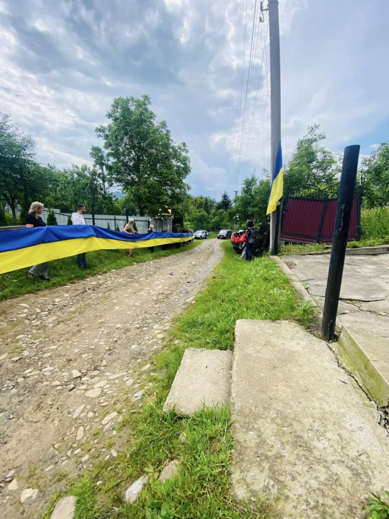 Люди тримають великий прапор України на вулиці