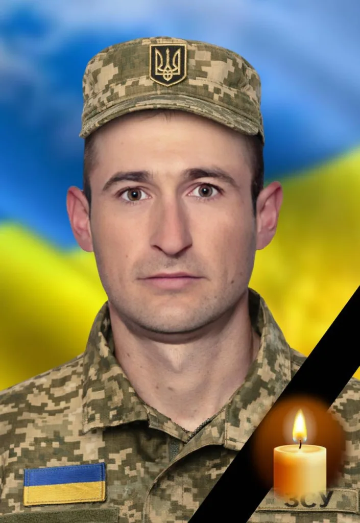 Український військовий на фоні прапора і свічки