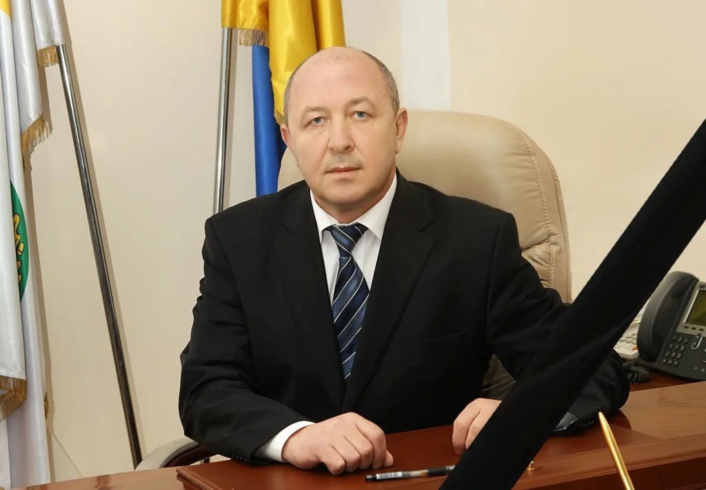 Чоловік у костюмі сидить за офісним столом
