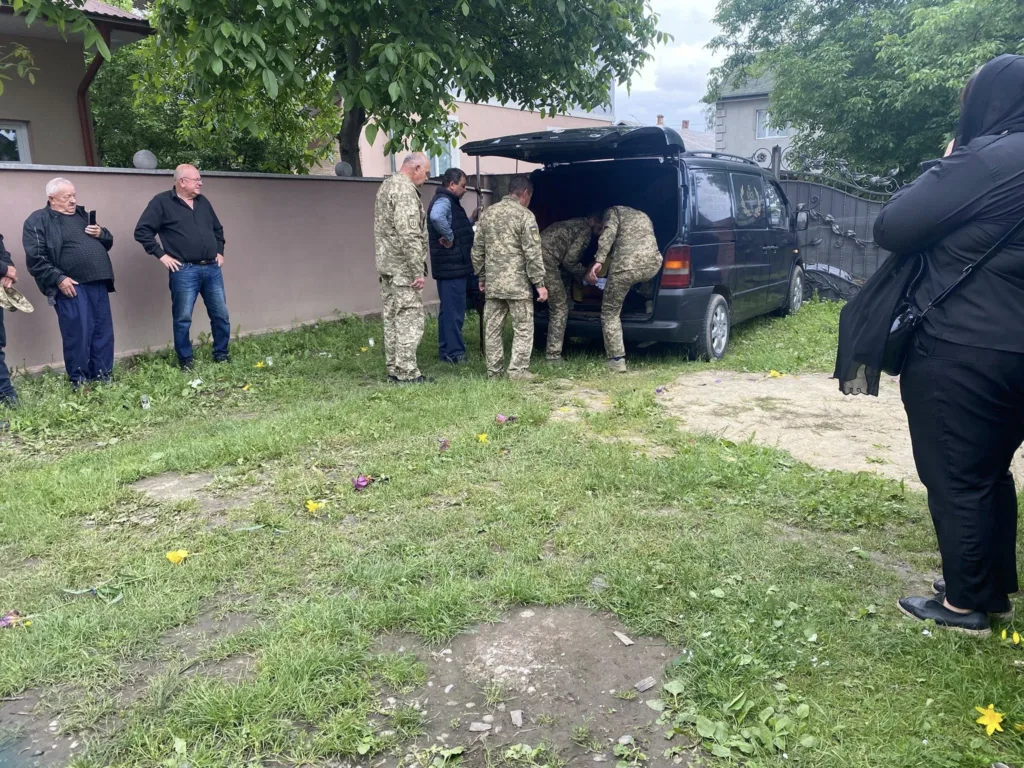 Військові біля чорного мікроавтобуса на подвір’ї