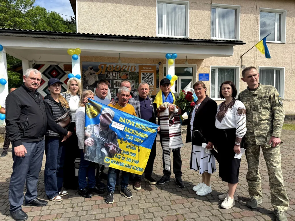 Люди біля будівлі з українським прапором