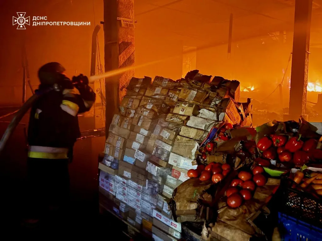 Пожежник гасить вогонь на складі з овочами