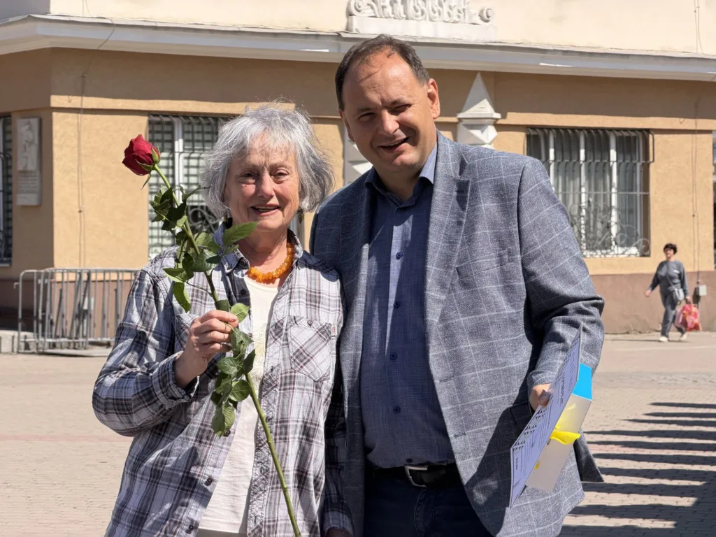 Двоє людей на вулиці, жінка тримає троянду