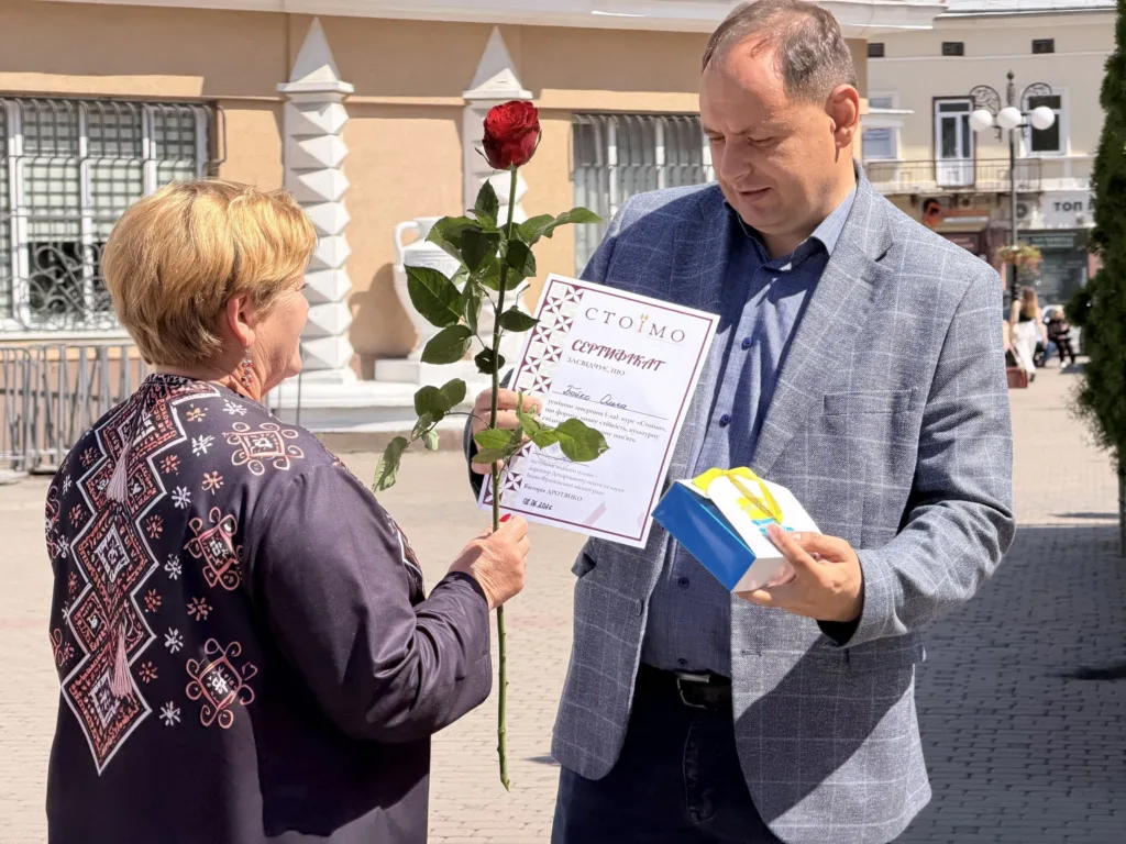 Чоловік отримує сертифікат і троянду на вулиці