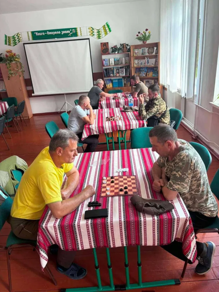 Чоловіки грають у шашки в бібліотеці