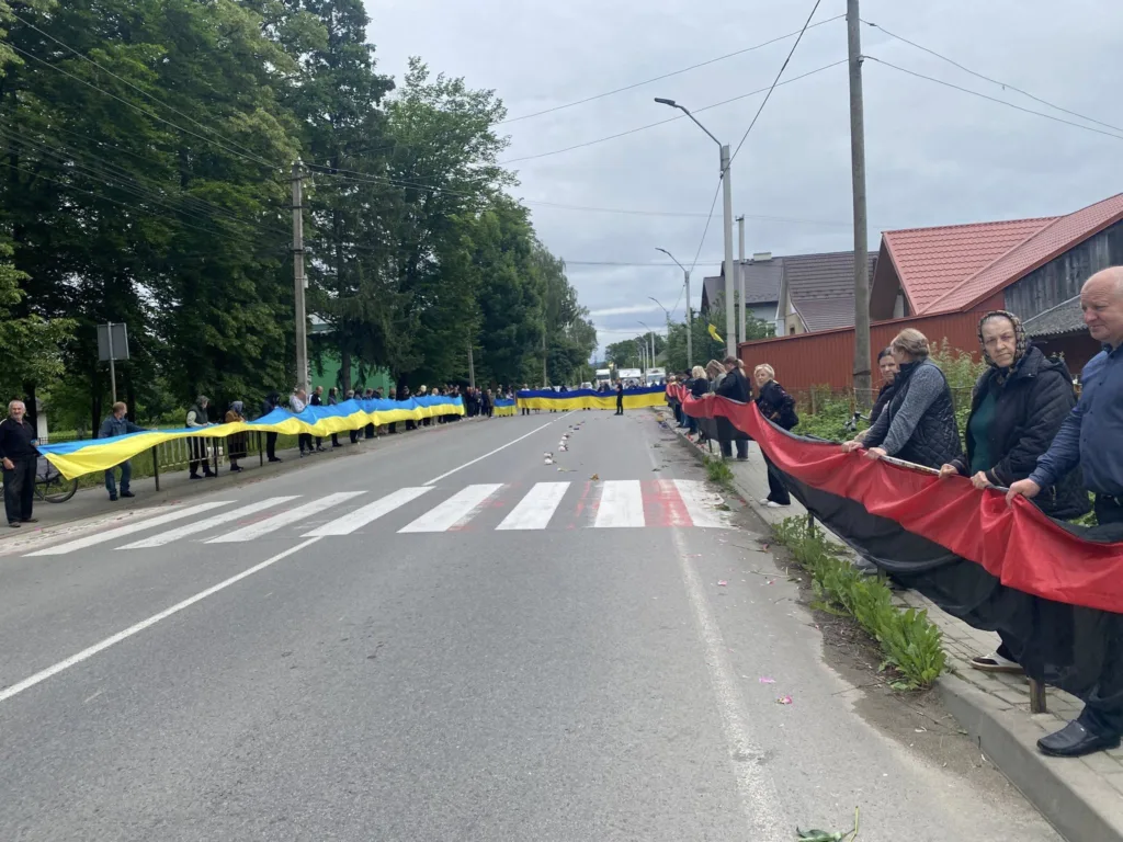 Люди тримають великі українські прапори на вулиці