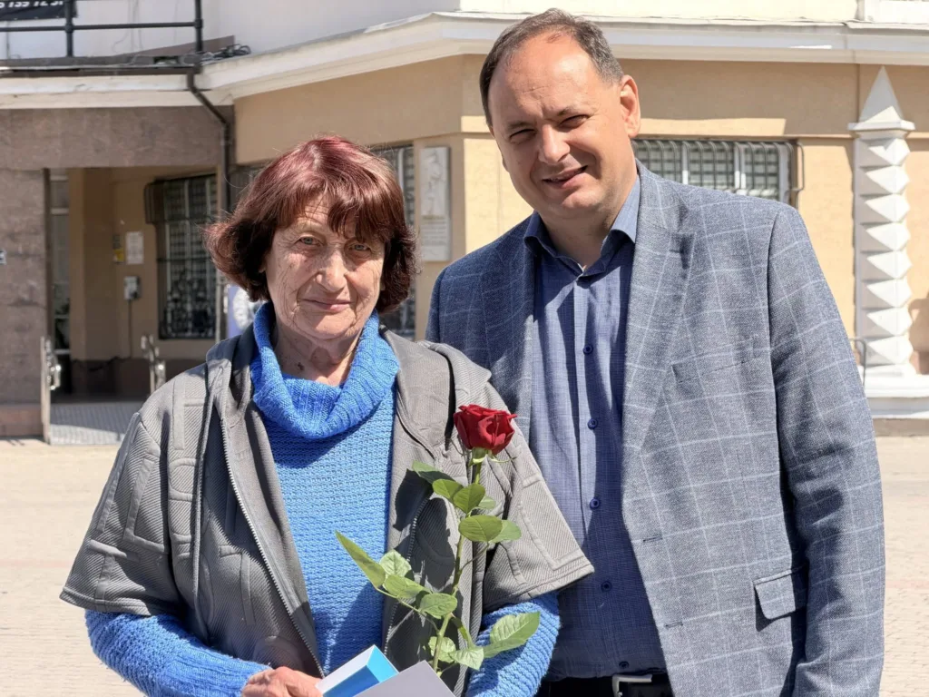 Жінка з червоною трояндою поруч із чоловіком