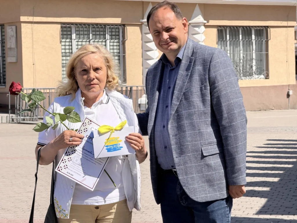 Жінка і чоловік з квіткою та сертифікатом