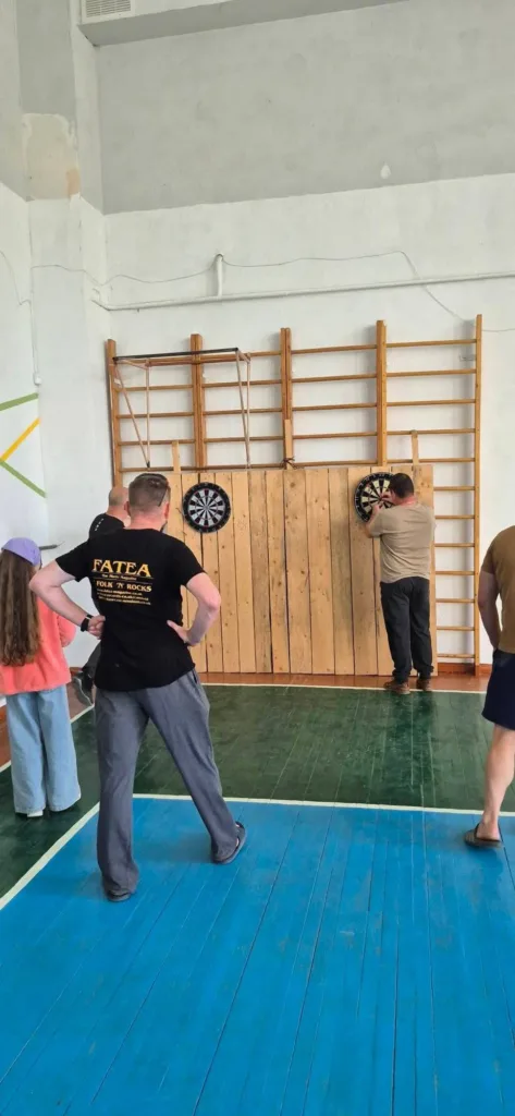 Люди грають у дартс у спортивному залі