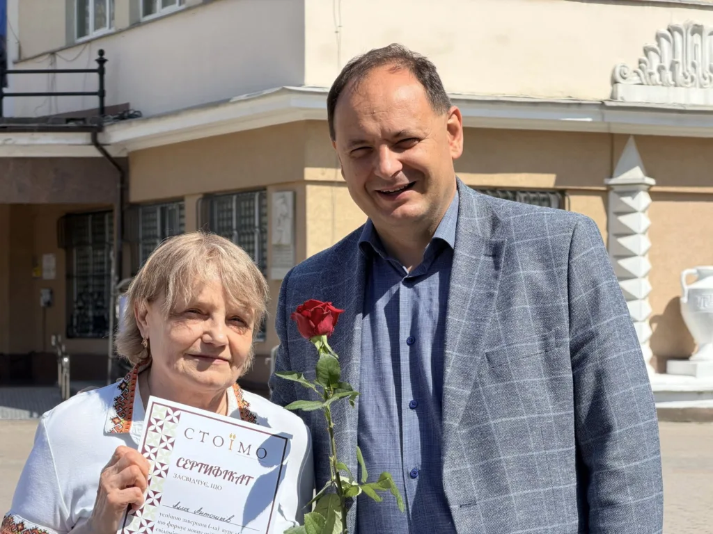 Жінка отримує сертифікат і троянду на вулиці