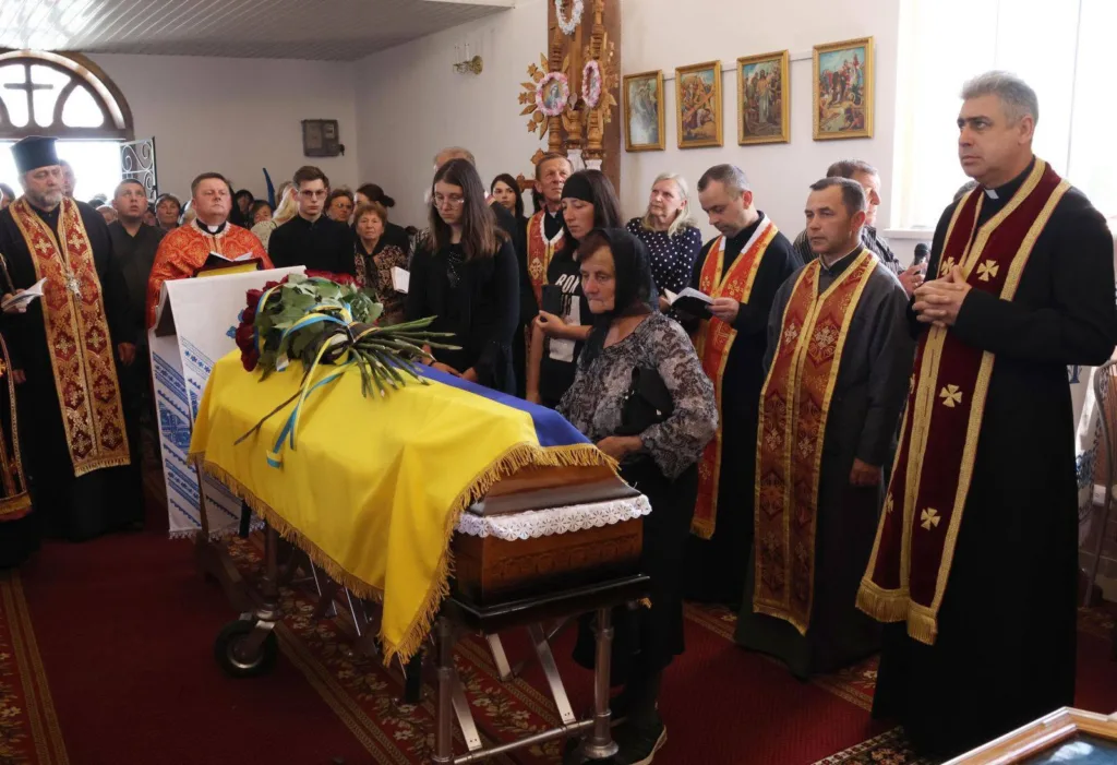 Похоронна церемонія з труною, накритою прапором України
