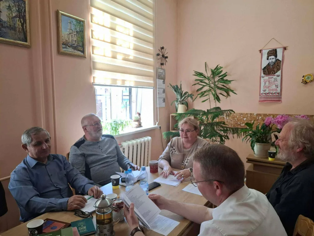 Група людей обговорює документи за столом
